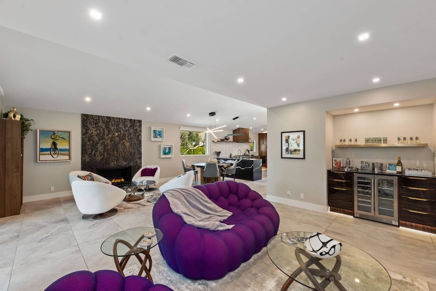 A home in Palm Springs for short term rental with a purple couch and fireplace
